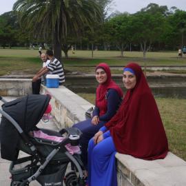 Two women and a baby sitting on a wall in Federal Park, Glebe, 2015