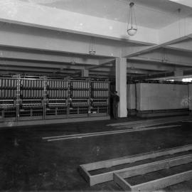 Factory interior with machinery and two men, unknown location, no date