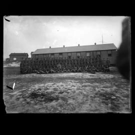 Regiment of soldiers outside barracks, unknown location, circa 1916