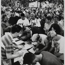 Writing the names of victims at a march against bashings and murder, 1990