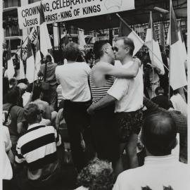 Protesters kiss among crowd, Kings Cross, 1990