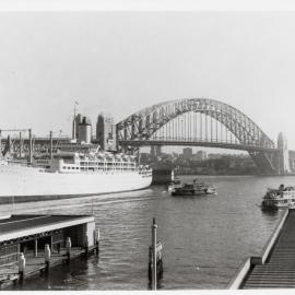 Circular Quay and Sydney Harbour Bridge with cruise ship, circa 1960s