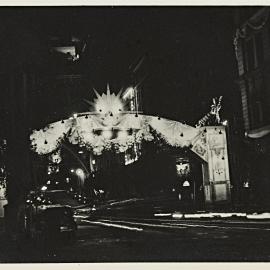 Arch decorations at night during royal visit of Queen Elizabeth II, Bridge Street Sydney, 1954