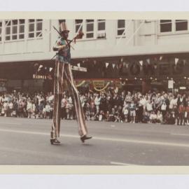 Man on stilts, Waratah Festival Parade, George Street Sydney, 1969