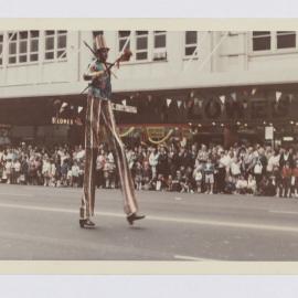 Man on stilts, Waratah Festival Parade, George Street Sydney, 1969