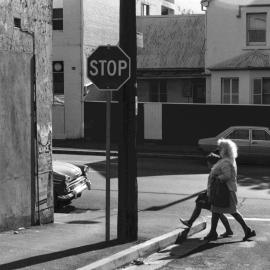 Woman and girl crossing an unidentified street in Surry Hills, 1976