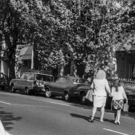 Woman and girl crossing an unidentified street in Surry Hills, 1976