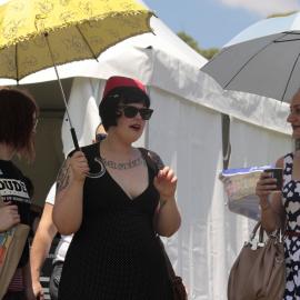 Three women two with umbrellas, Victoria Park, Mardi Gras Fair Day, 2012
