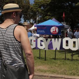 Man in striped t-shirt by the Doggywood sign, Victoria Park, Mardi Gras Fair Day, 2012