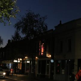 Lights in the shops are on in Glebe Point Road, Glebe, 2021