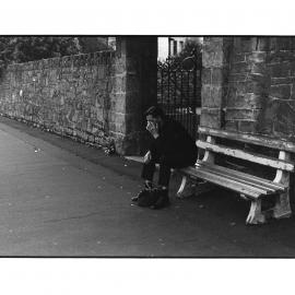 Man on bench outside churchyard