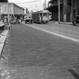 Woodblocking the road alongside tramline, Cleveland Street Redfern, 1929