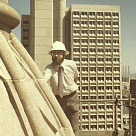 Contractor on clock tower of Sydney Town Hall with Town Hall House behind, 1981