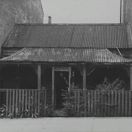 Front facade of a dilapidated weatherboard cottage, Windsor Street Paddington, 1952