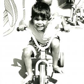 Children on a tricycle.