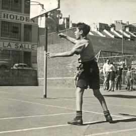 Boy playing badminton at Woolloomooloo Children's Playground, 1951