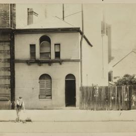 Print - Block boy in front of dwelling in Kent Street Sydney, circa 1909