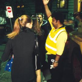 City cleansing staff member giving directions to late night revellers York Street Sydney, 2000