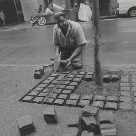 Workman lay blocks around a tree base in the new wider footpaths, Pitt Street Sydney, 2000