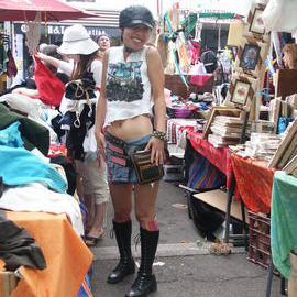 A woman in a leather cap posing in between Glebe Market stalls, Glebe Point Road Glebe, 2003