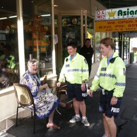 Bicycle policewomen on foot talking to a woman, Glebe Point Road Glebe, 2003