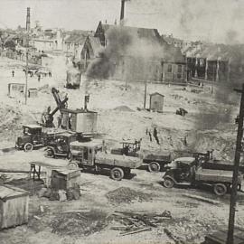 Steam shovel and trucks, Brisbane Street area resumption Surry Hills, 1928