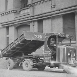 An Engineering and Building Surveyors Department truck unloads gravel, 1935