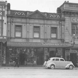 Looking west to shops and parked vehicle, George Street Sydney, 1942