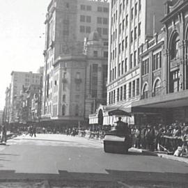 Crowd watching asphalting roadworks near Sydney Town Hall, George Street Sydney, 1931