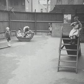 Children on equipment in asphalted playground, Palmer Street Woolloomooloo, circa 1950