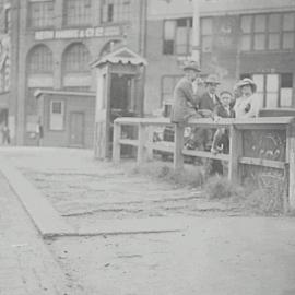 View of damaged footpath, and family waiting for Tram, Railway Square, Lee Street Sydney, 1935