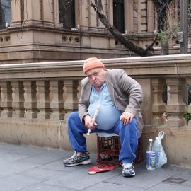 Busker with red hat for donations, plays recorder, Sydney Town Hall, George Street Sydney, 2004