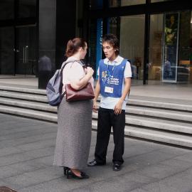 Buskers,  view of a Cancer Council representative talking to passer-by, George Street, Sydney, 2004