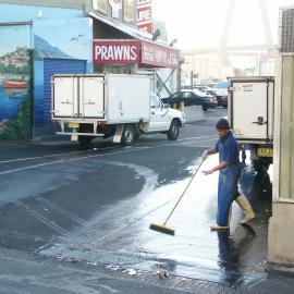 Fish market's employee sweeping up outside fish vendors, Bank Street Pyrmont, 2003