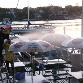 Fish market's employee hosing down umbrellas, Bank Street Pyrmont, 2003