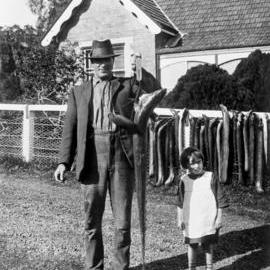 Man with catch of eels, location unknown, circa 1920-1929