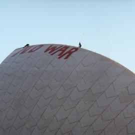 No War poster on Opera House sails, Circular Quay Sydney, 2003