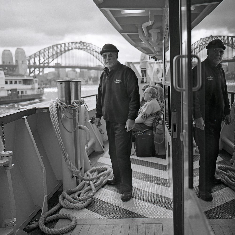 Ferry crewman with Harbour Bridge in background, Circular Quay Sydney, 2001 by Tim Cole (A-00083755)