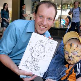 Caricature artist with sketch and subject, Queen Victoria Building (QVB), George Street Sydney, 2005