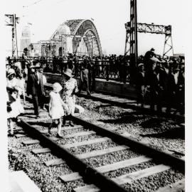 Family walking along Sydney Harbour Bridge train tracks during opening celebrations, Sydney, 1932