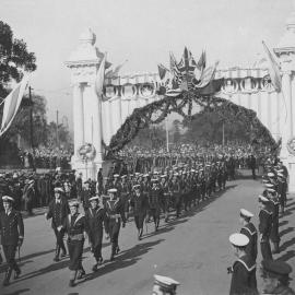 Navy officers walking through Victory Arch, Victory Day celebrations, Sydney 1919