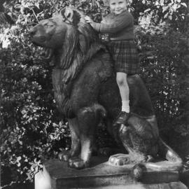 View showing young girl sitting on lion statue, Botanical Gardens Sydney, 1938