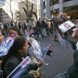 Watching the parade, children wave flags, ANZAC Day, George Street Sydney, 1997