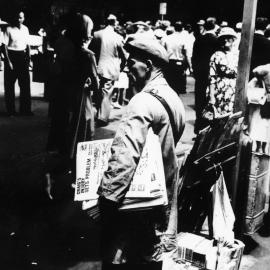 Newspaper vendor at George Street and Market Street Sydney, 1950