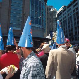 Crowd wearing cone hats on George Street before the Olympic Athletes tickertape parade, Sydney, 2000